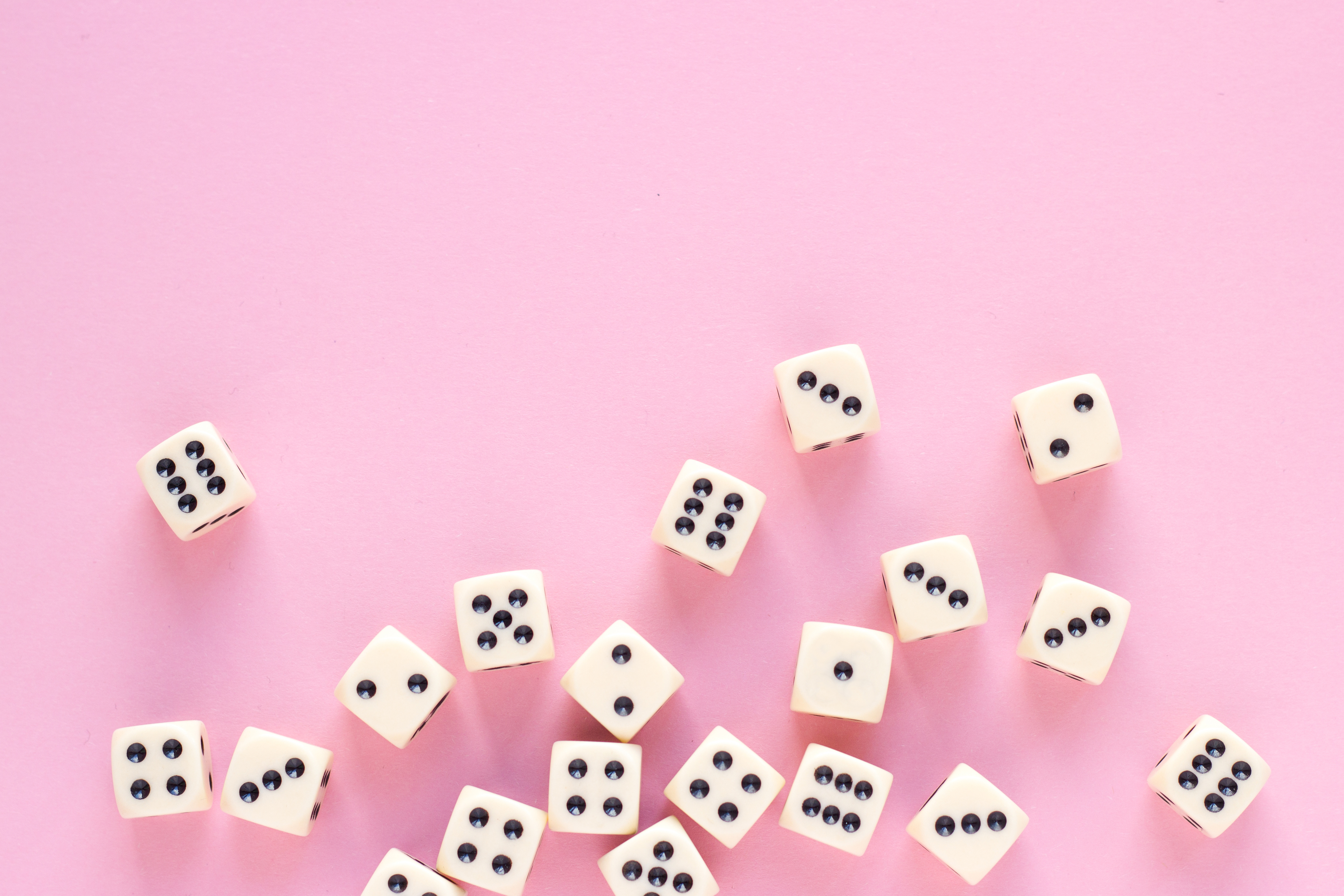 Pink background with a bunch of rolling dice